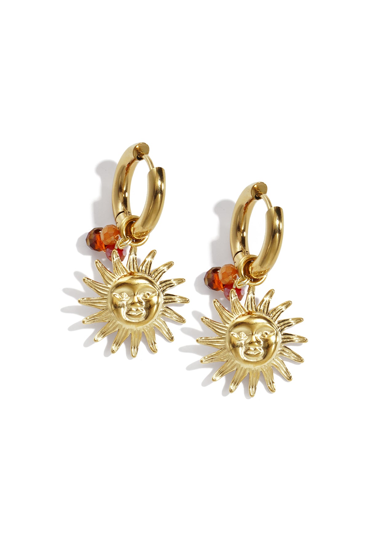 Gold-tone hoop earrings with sun face charms and orange beads on white background
