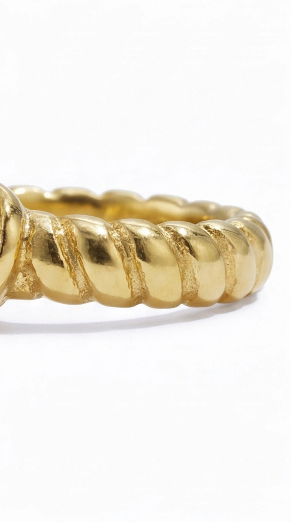 Gold ring with a textured design on a white background