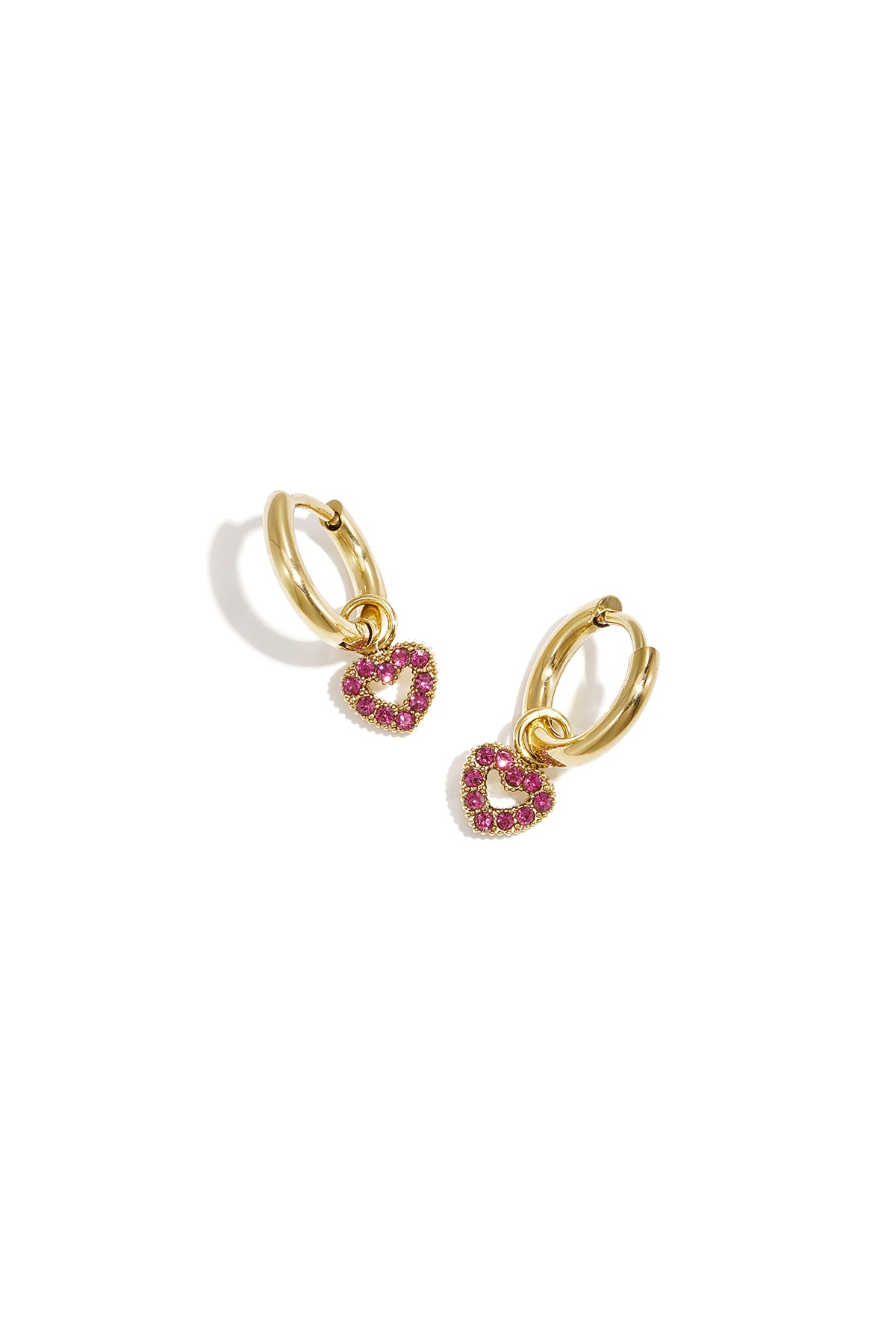Gold hoop earrings with ruby red rhinestone outlined heart charm on a white background