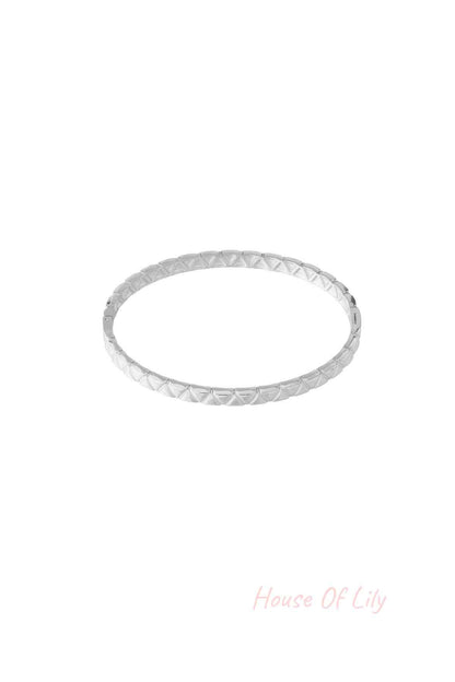Silver textured bangle with geometric pattern isolated on white background
