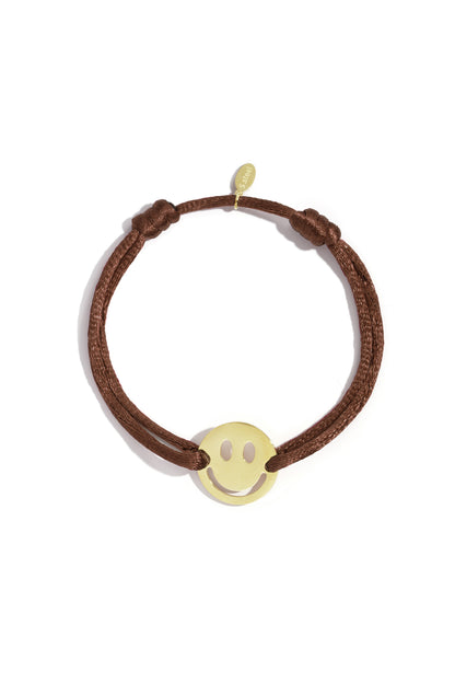 Cheerful Smiley Face bracelet featuring a gold-tone stainless steel smiley charm on a brown cord with adjustable knots.