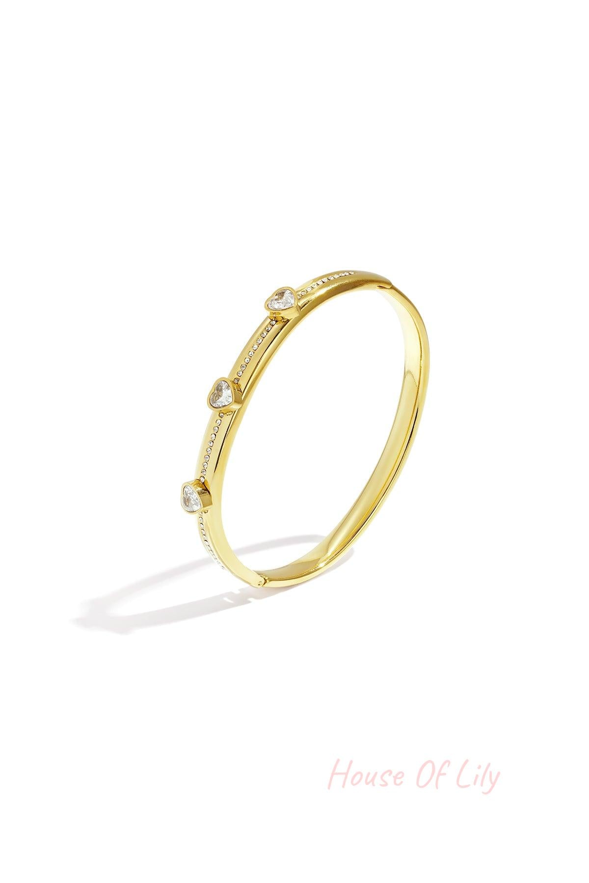 Gold tone heart crystal accent bangle isolated on white background