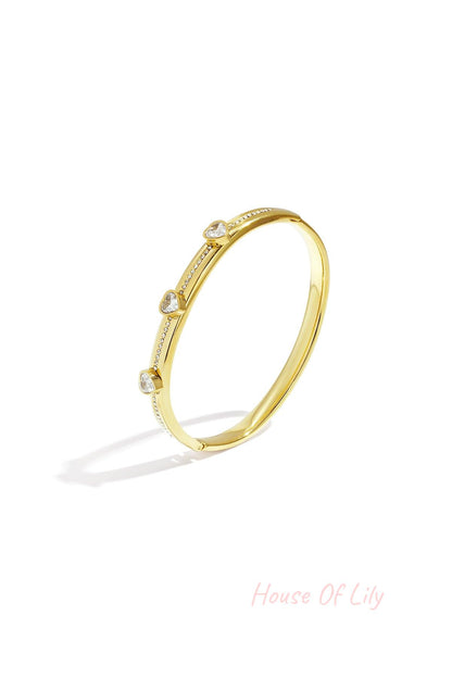 Gold tone heart crystal accent bangle isolated on white background