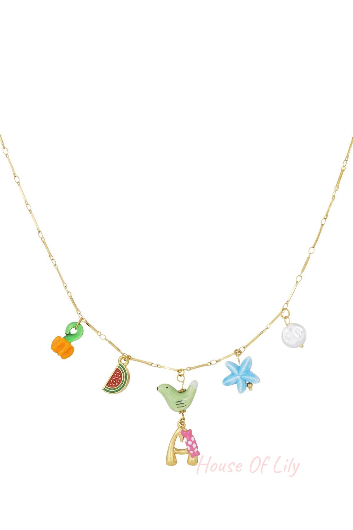 Gold chain necklace with colorful charms including orange pumpkin, watermelon slice, green bird, blue starfish, white pearl, and gold letter A with pink bow pendant