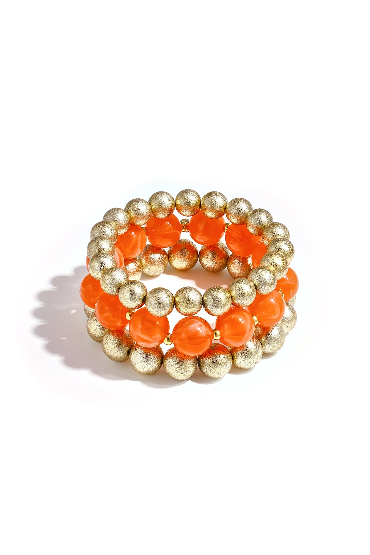 Set of three beaded bracelets with orange marbled beads and textured gold spheres on white background
