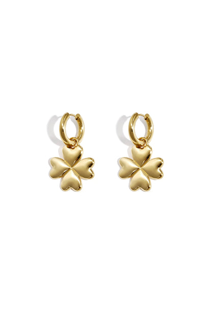Pair of gold four-leaf clover hoop earrings with heart-shaped petals on white background