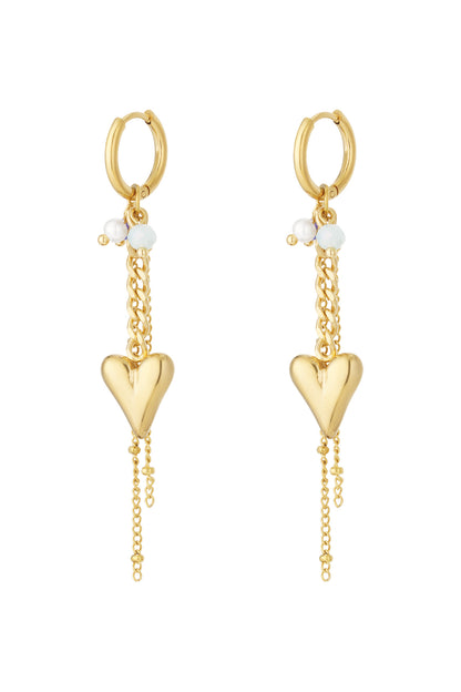 Pair of gold-tone hoop earrings with hanging heart pendants and small pearl and blue beads on a white background