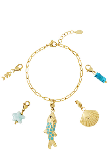 Gold charm bracelet with five detachable charms featuring a turquoise enamel fish, gold scallop shell, fish skeleton, light blue starfish, and turquoise beads on a white background