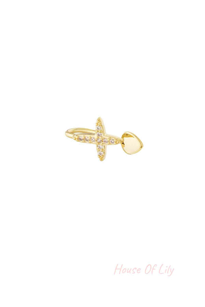 Close-up of gold nose and ear cuff featuring a cross adorned with clear cubic zirconia stones and a smooth heart-shaped end