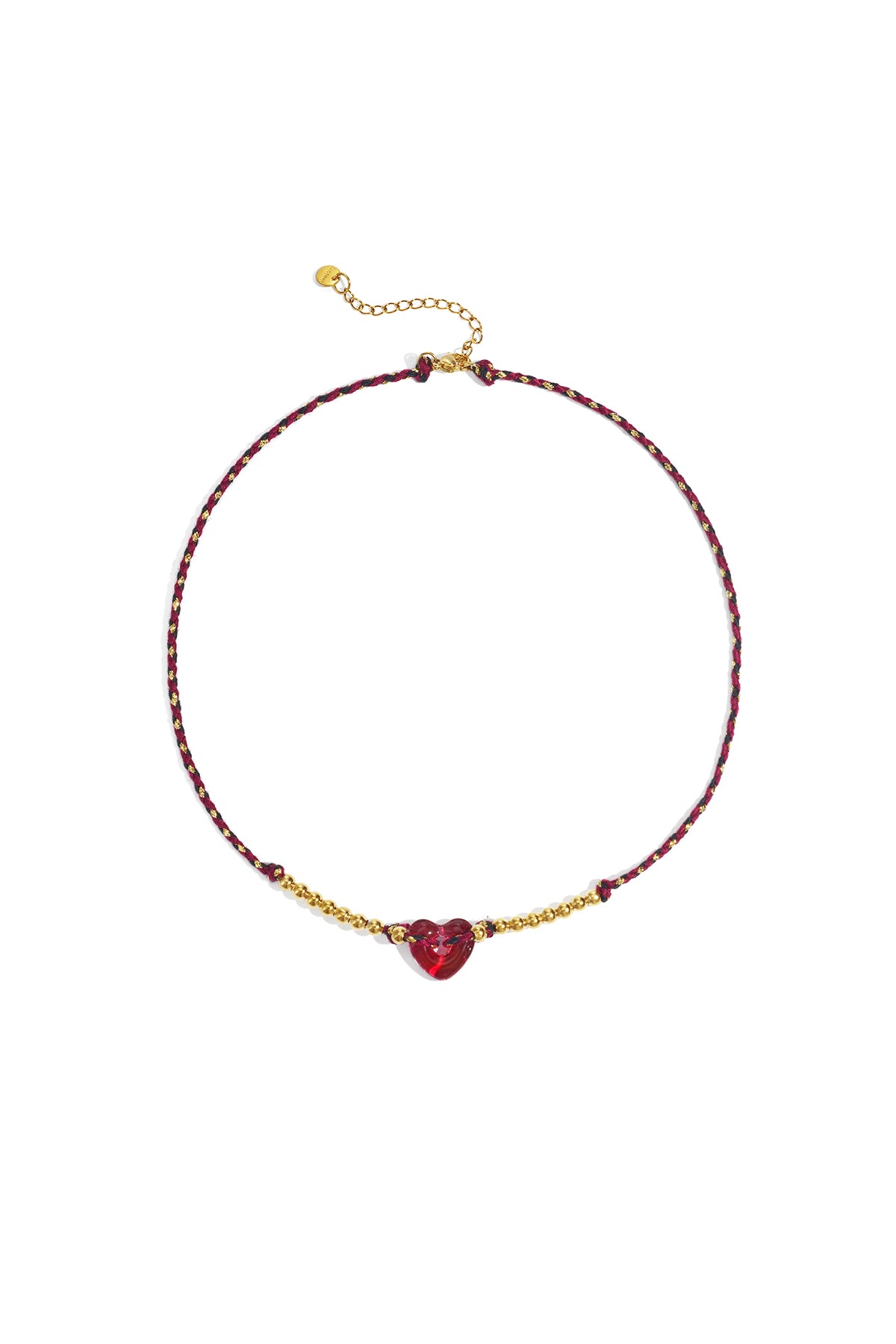 Red braided necklace with red translucent heart bead and gold-tone beads on white background