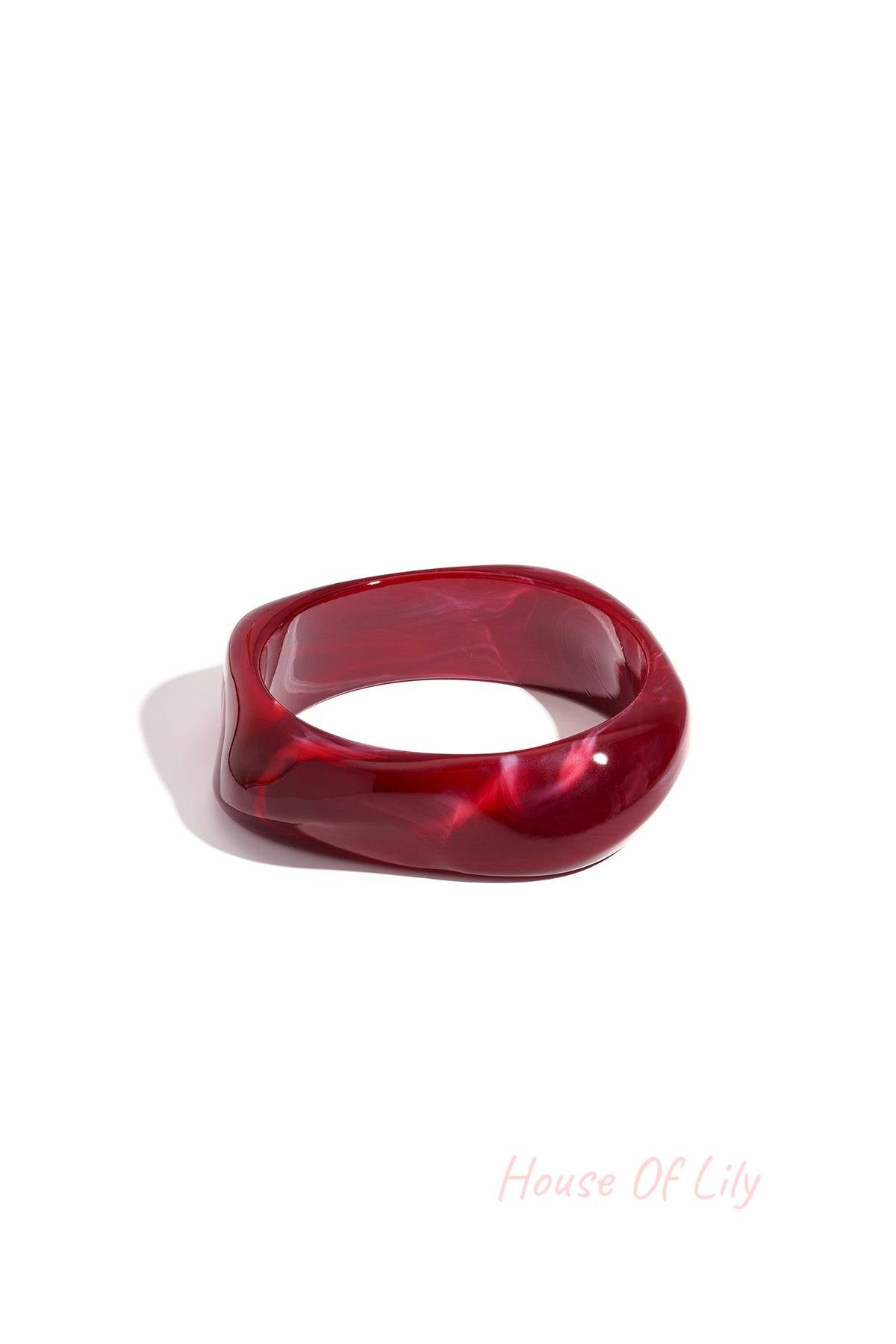 Single deep burgundy acrylic wavy square bangle on a white background