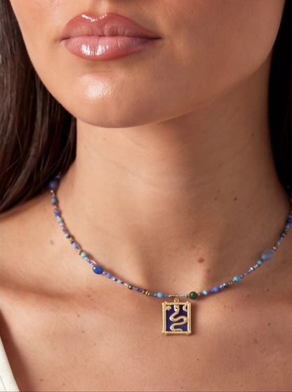 Necklace with a pendant worn by a person, focusing on the necklace and skin texture.