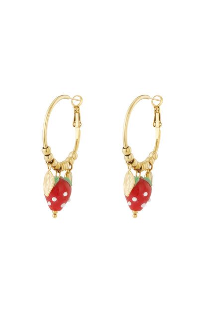 Pair of gold-plated hoop earrings with red enamel strawberry and gold leaf charms isolated on white background