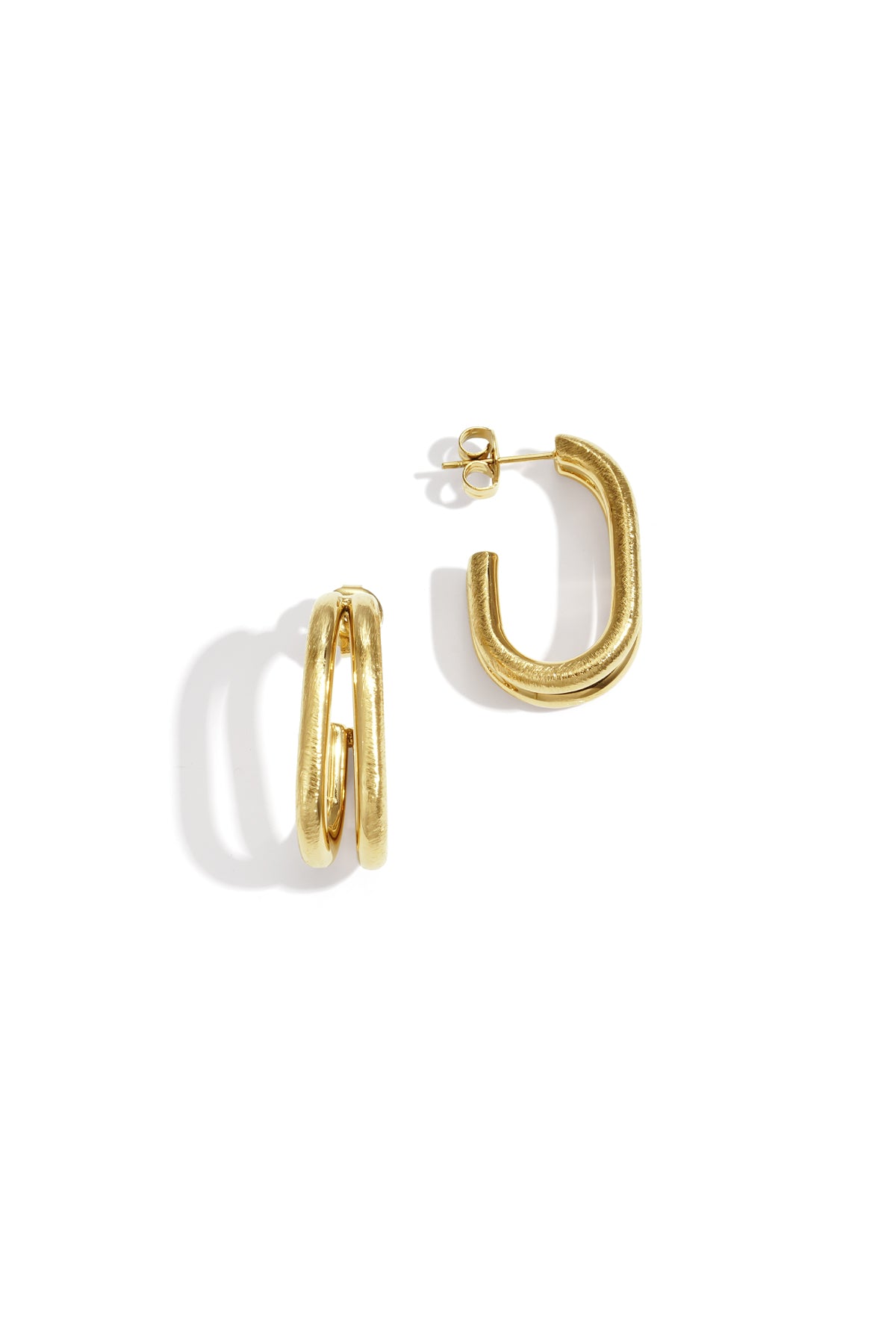 Close-up of gold chunky double loop earrings with textured finish on white background