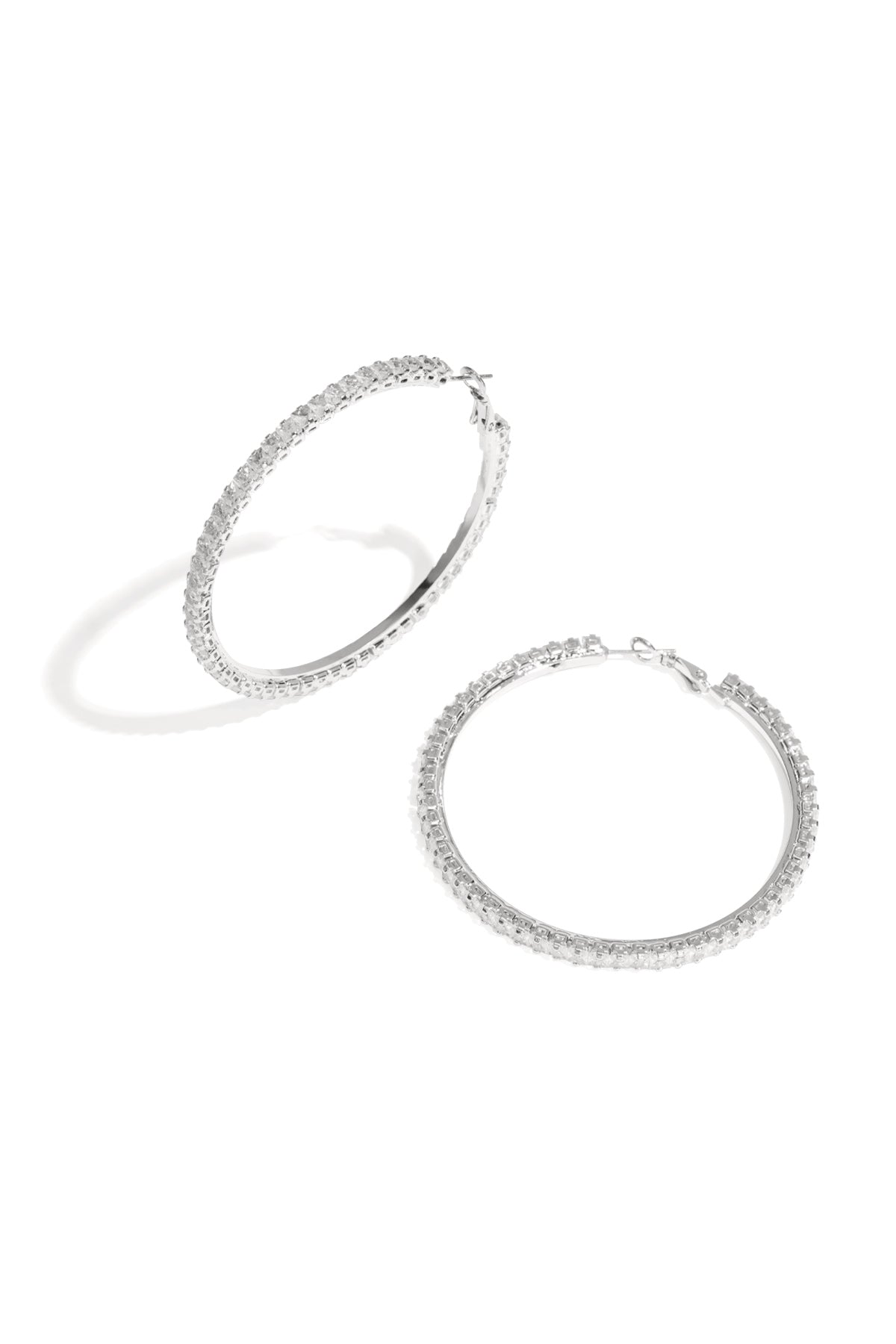 Pair of silver-tone hoop earrings encrusted with clear crystals on white background