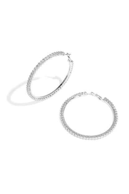 Pair of silver-tone hoop earrings encrusted with clear crystals on white background