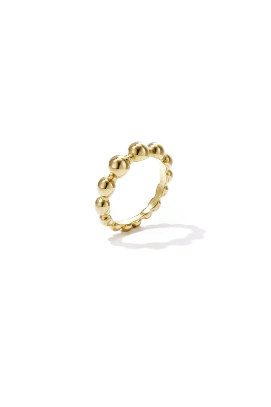 Close-up of a gold beaded statement ring with smooth round beads on a white background