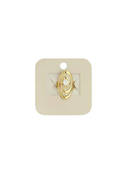 Gold ring with a modern oval-shaped swirl design featuring a central clear gemstone, displayed on a beige card.