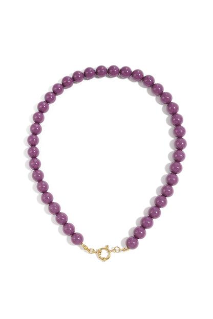 Short purple resin bead necklace with a gold-tone circular clasp, isolated on a white background.