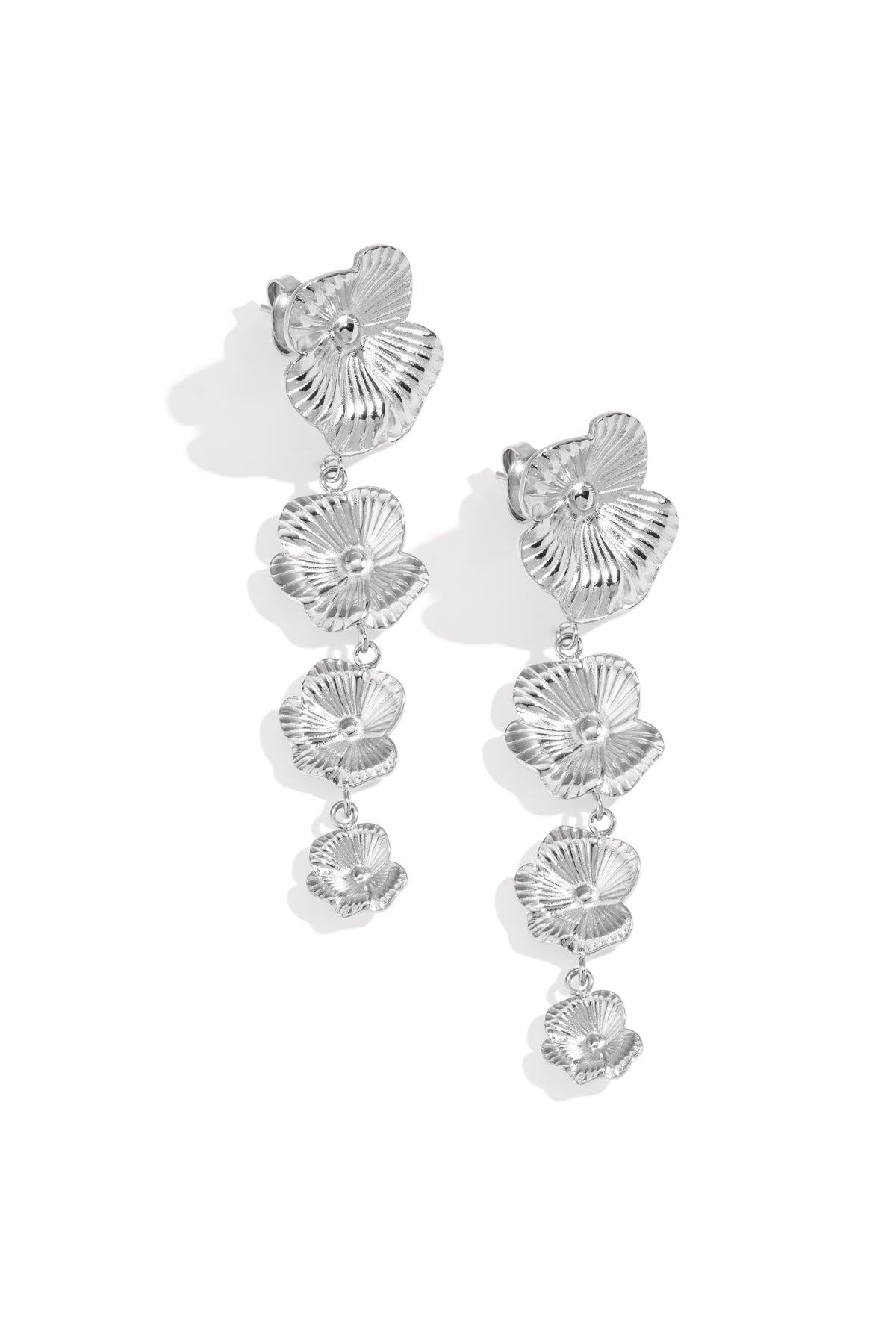 Silver floral cascade dangle earrings laying flat on white background