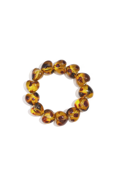 Close-up of a leopard print heart-shaped acrylic beaded bracelet in amber tones on white background