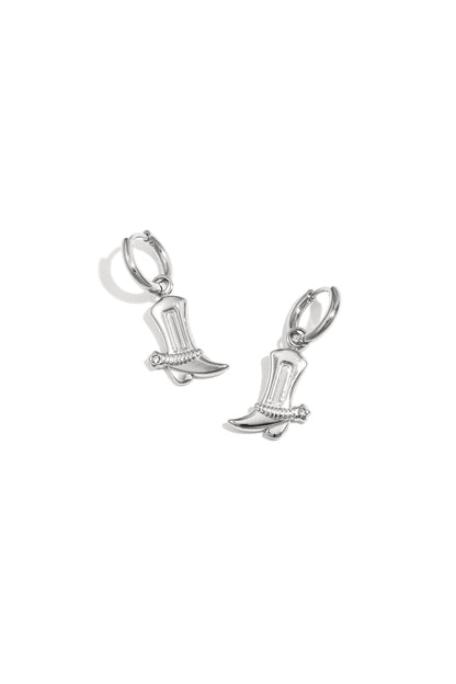 Pair of silver cowboy boot charm drop earrings with rhinestone detail on white background