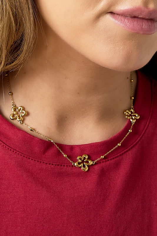 Soft Petal Drop necklace: A delicate gold chain featuring evenly spaced gold flower charms with small bead accents.
