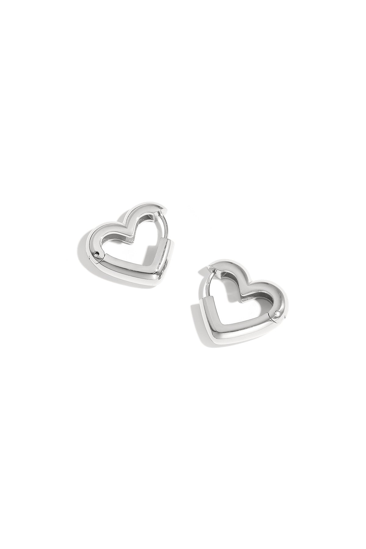 Pair of silver heart-shaped hoop earrings with polished finish on white background