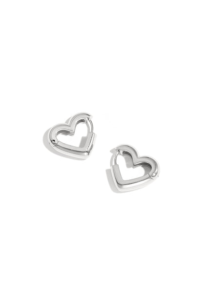 Pair of silver heart-shaped hoop earrings with polished finish on white background