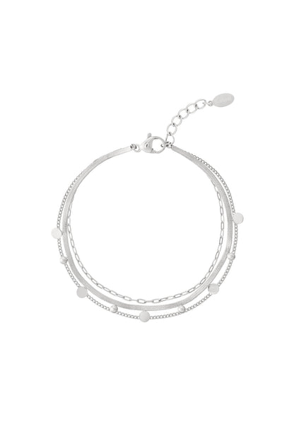 Close-up of a silver layered chain bracelet with small round dot accents and lobster clasp on white background