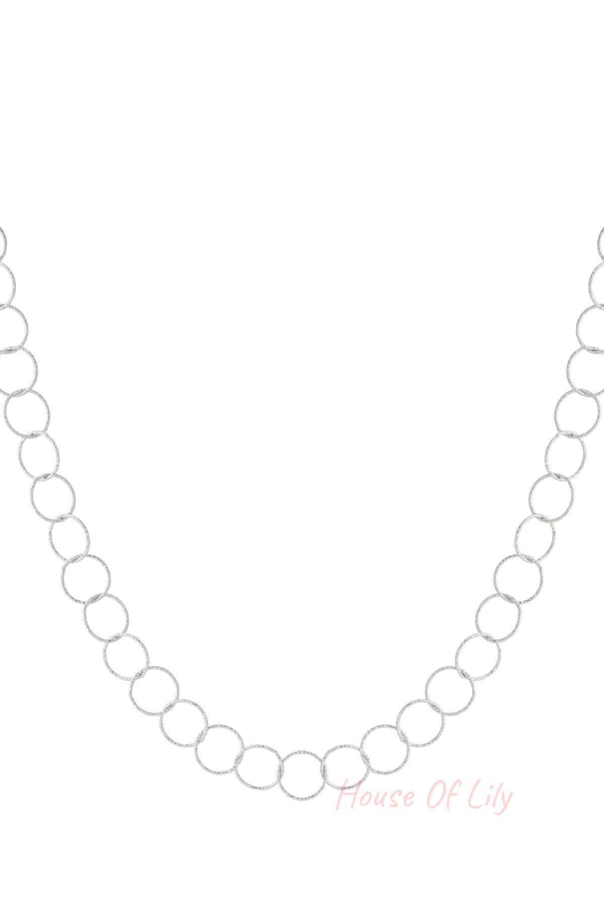 Close-up of textured loop chain necklace in silver tone on white background