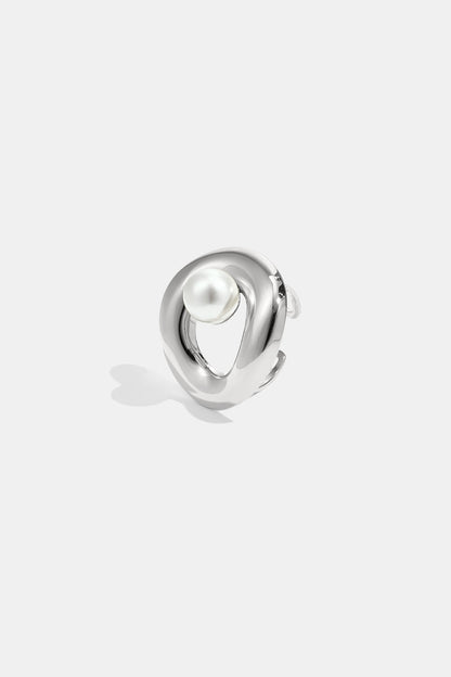 Close-up of a silver sculpted statement ring with a single white pearl on a white background