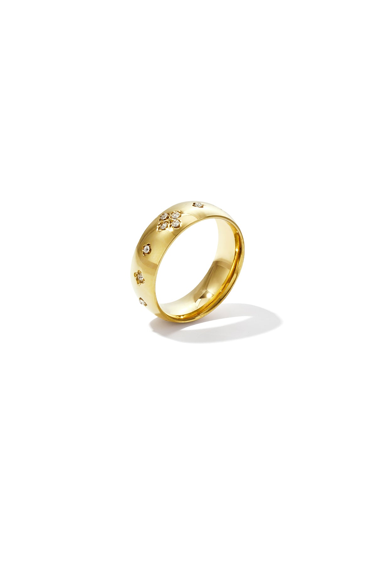 Close-up of a gold-tone ring with sparkling crystal rhinestones in a clover pattern on a white background