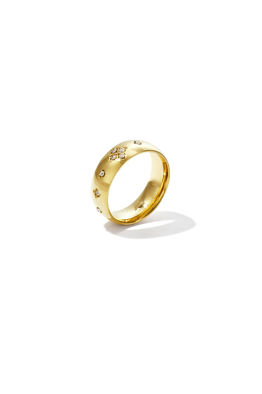 Close-up of a gold-tone ring with sparkling crystal rhinestones in a clover pattern on a white background