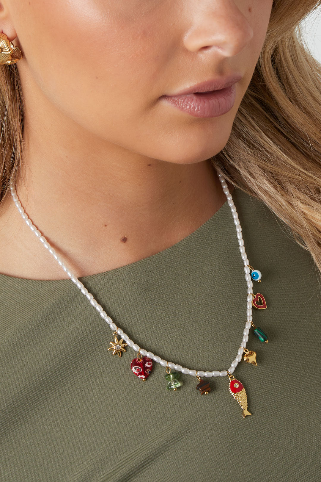 Model wearing the beaded charm necklace showcasing the vibrant charms against a green top