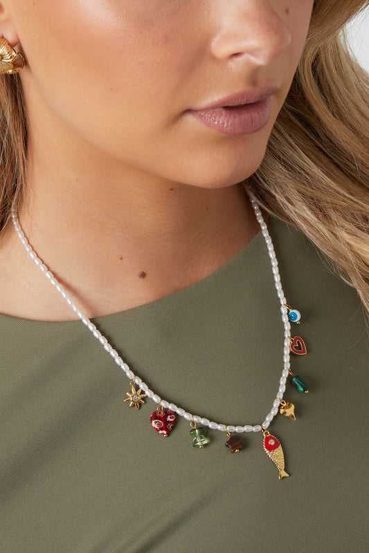Model wearing the beaded charm necklace showcasing the vibrant charms against a green top