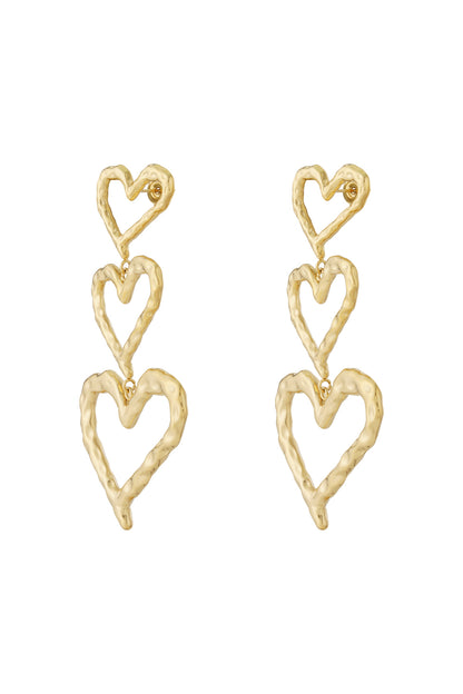 Pair of gold-tone triple heart dangle earrings with hammered textured metal on white background