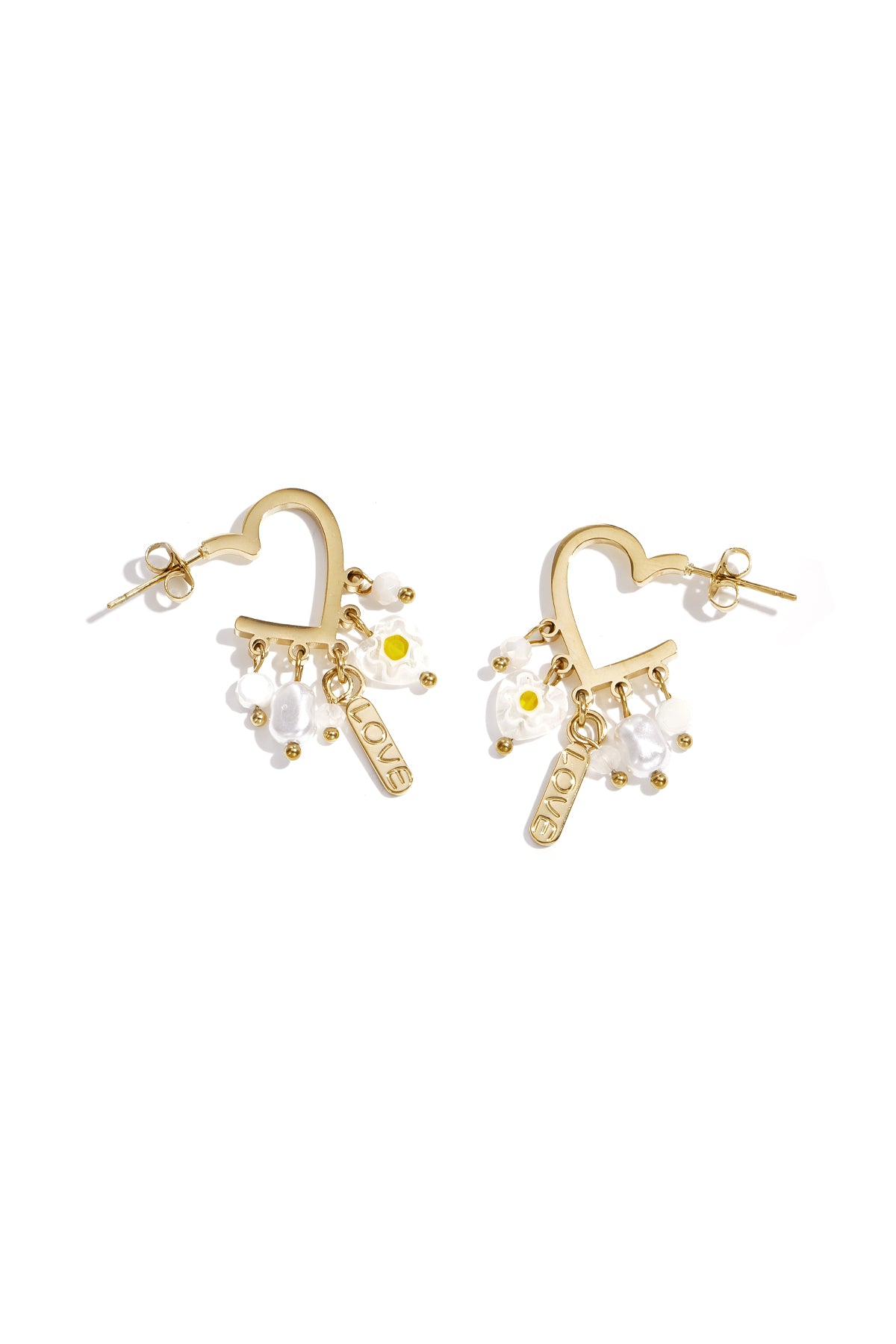 Pair of gold-tone heart-shaped drop earrings with dangling white beads, pearl-like drops, floral charms, and a LOVE tag on a white background