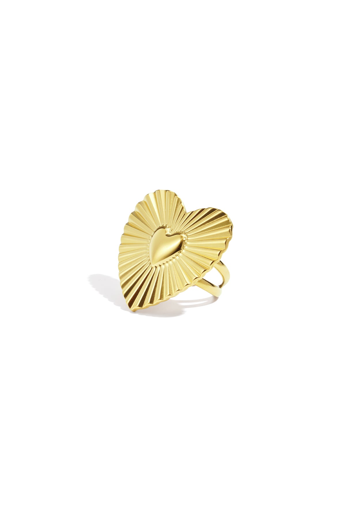 Close-up of a gold heart-shaped statement ring with sunburst texture on a white background