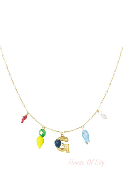 Gold charm necklace with gold starfish, orange coral, gold letter L with turtle charm, white seashell, and orange fish charms