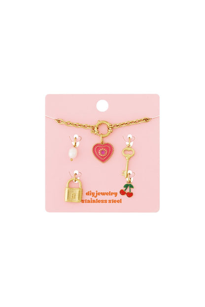 Gold chain bracelet kit with heart, lock, key, cherry, and pearl charms on a pink display card.