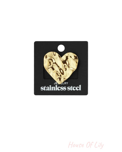 Gold-colored stainless steel heart-shaped pendant with hammered texture, displayed on a black cardboard backing.