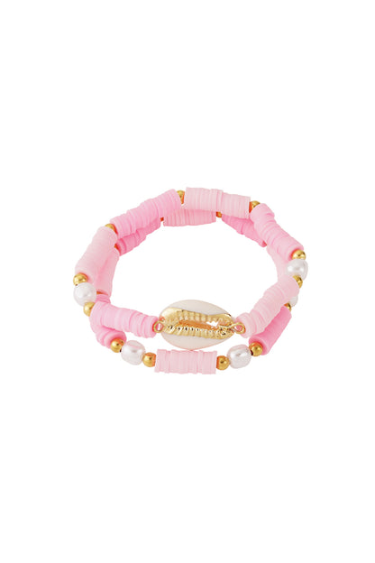 Pink shell beaded bracelet set made of soft polymer discs, gold-tone beads, and faux pearls on white background