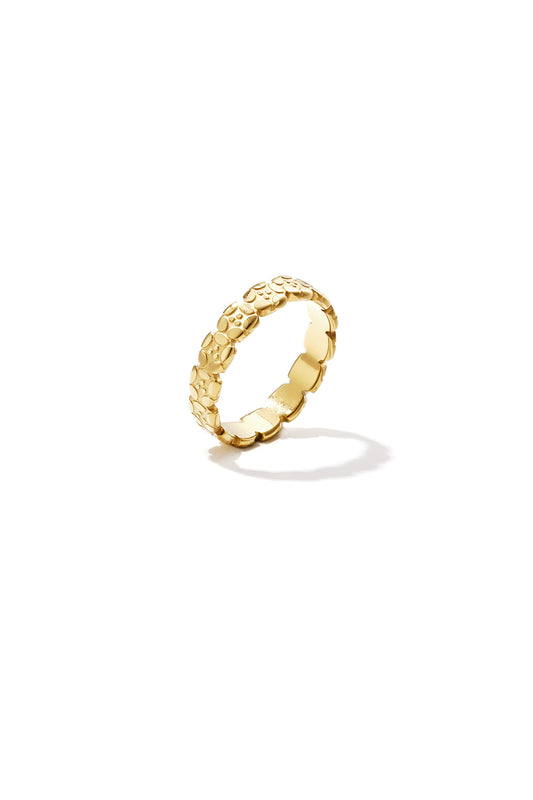 Close-up photo of a gold ring with an embossed floral pattern on a white background casting a shadow
