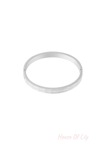 Single silver-tone bangle featuring a row of small sparkling crystals, isolated on white background