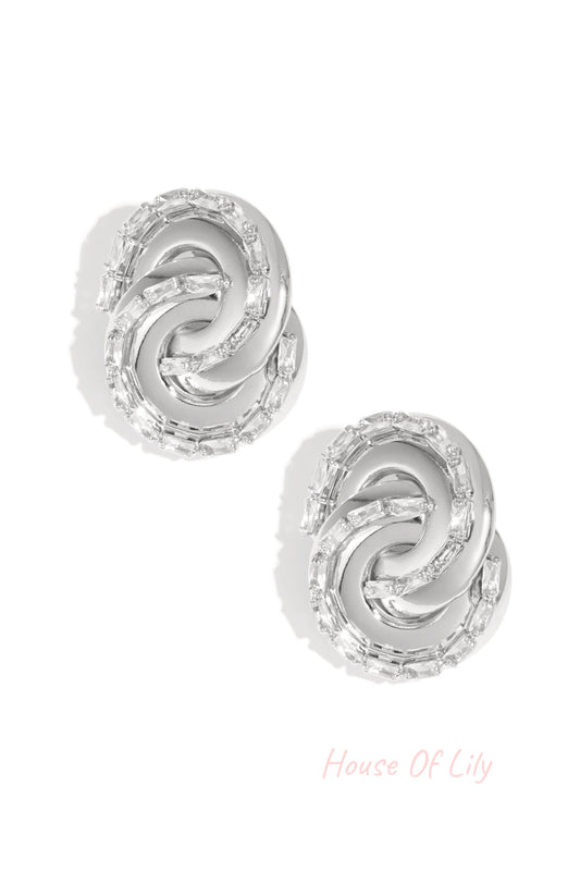 Silver-toned twisted chain stud earrings with baguette-cut crystals on white background