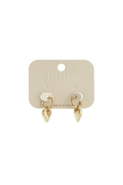 Gold hoop earrings with textured, heart-shaped charms attached to a beige display card.