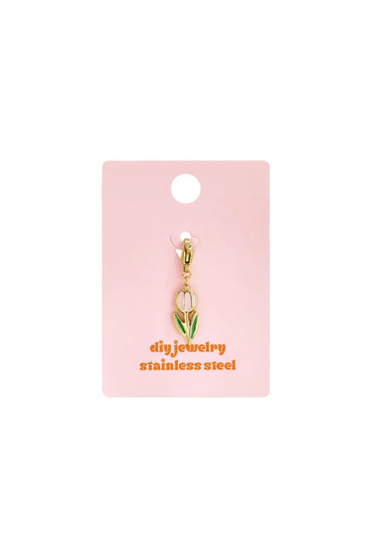 Gold-tone stainless steel tulip charm with pink and green enamel detail on a branded pink display card.