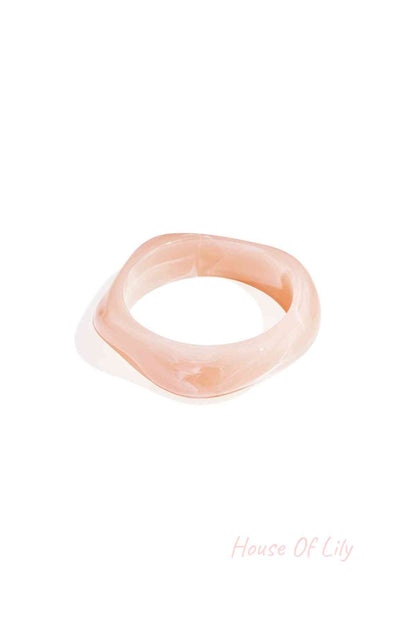 Single ivory white marbled acrylic wavy square bangle on a white background