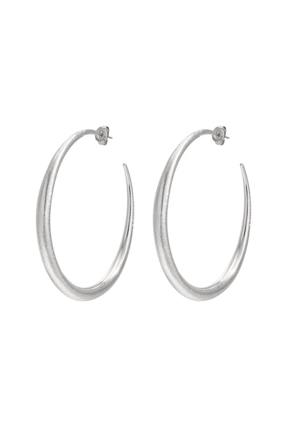 Pair of sculpted silver hoop earrings with tapered design on white background